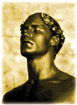 [This is a photo of a man's head, painted gold, wearing an olive branch for a hat, ala Julius Caesar. Very appropriate.]