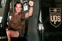 [This is a photograph of a happy postal worker. It's gotta be some kind of ad campaign. The smiling ups employee is actually an actor.]